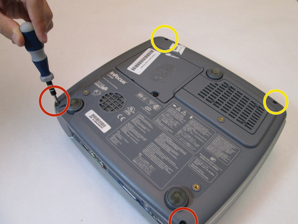 Image 1/2: Remove the two 77mm screws that are located nearest to the back panel ports. Use the T10 Torx screwdriver head.
